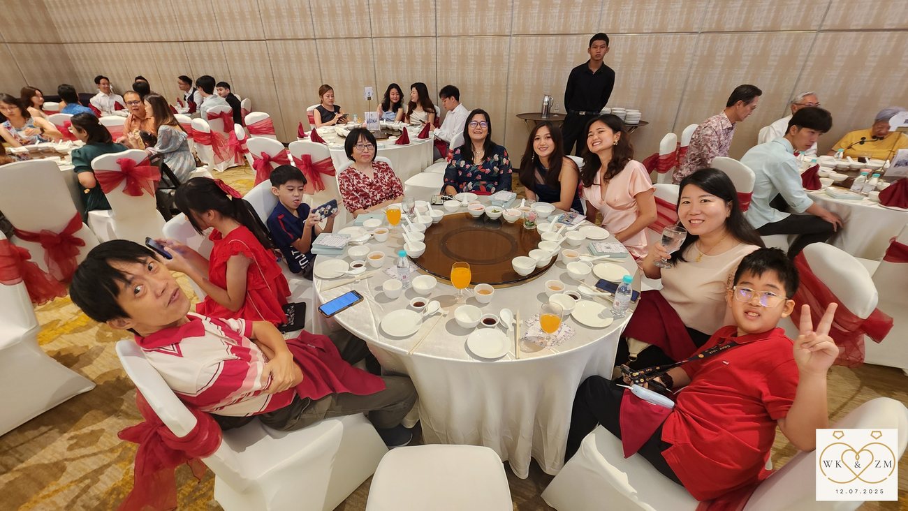 A full table of guests in red, mid-toast during the banquet